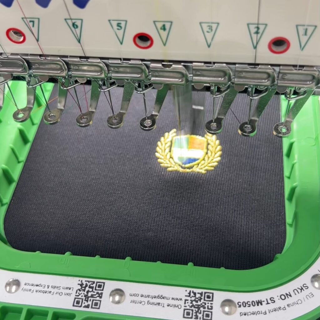 검정 원단에 엠블럼 자수를 놓는 중