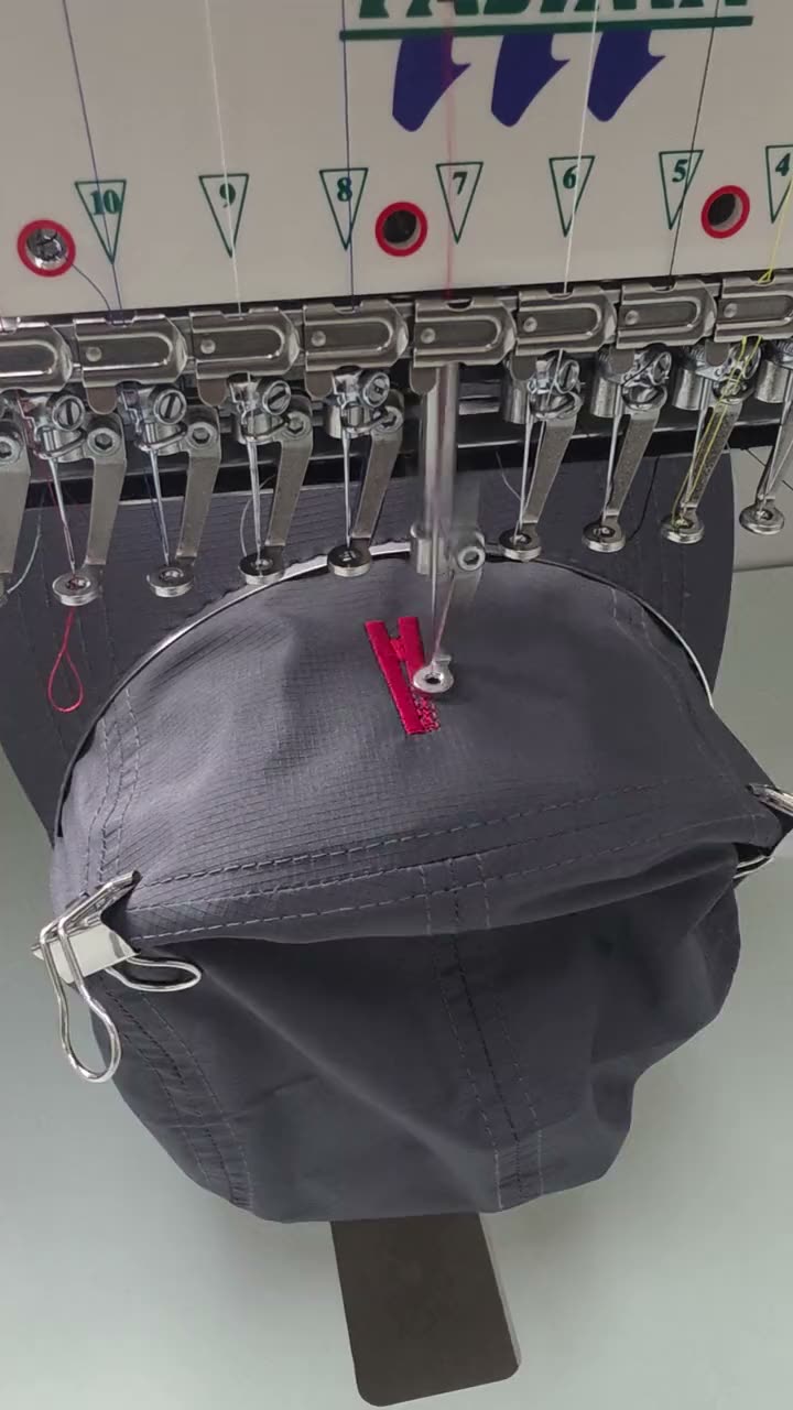 캠프캡에 자수 중인 자수기 바늘